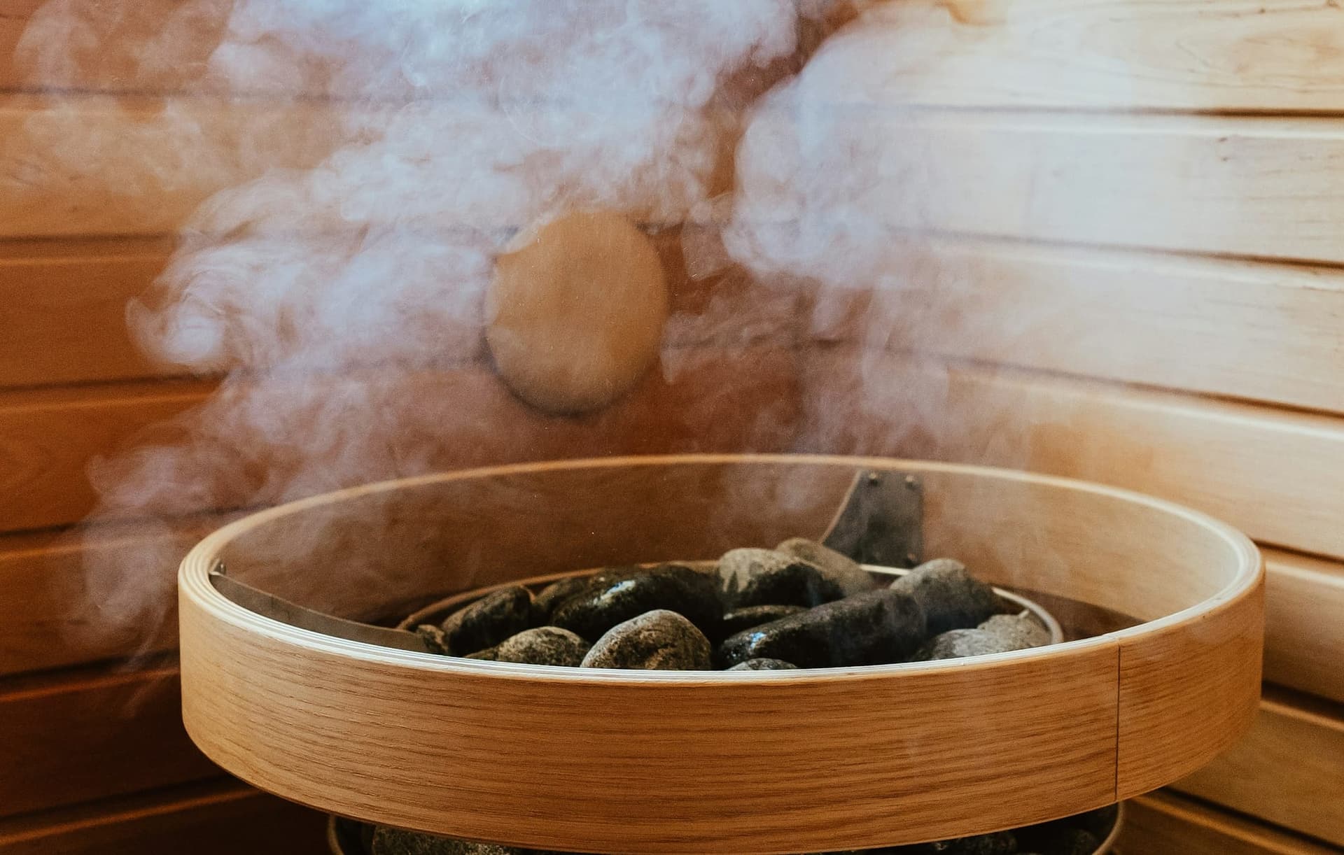 Vapor que sube de las piedras calientes de un sauna de madera