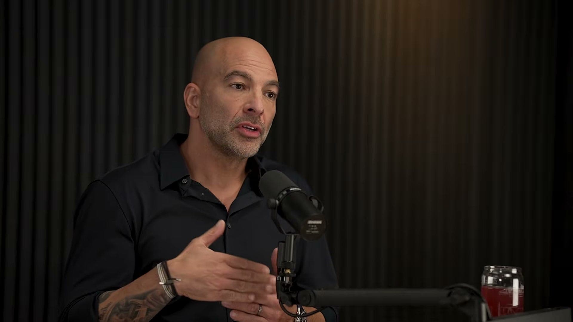 Peter Attia hablando en un estudio oscuro durante el episodio 407 de su podcast The Drive
